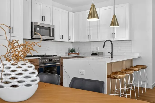 a kitchen with stainless steel appliances a stove a sink and a microwave