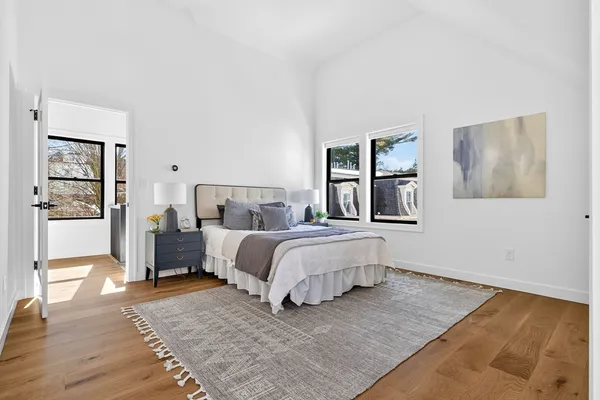 a bedroom with a bed lamp on desk and a window