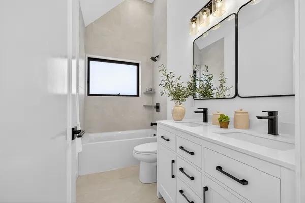 a bathroom with a granite countertop sink a toilet a mirror and shower