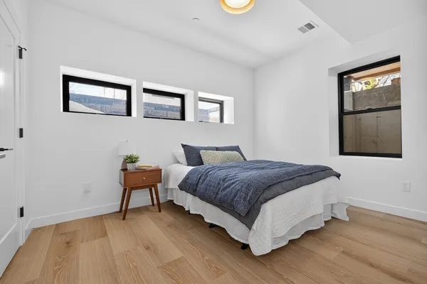 a bedroom with a bed and wooden floor