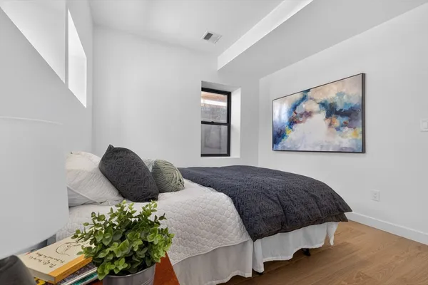 a bedroom with a bed and a painting on the wall