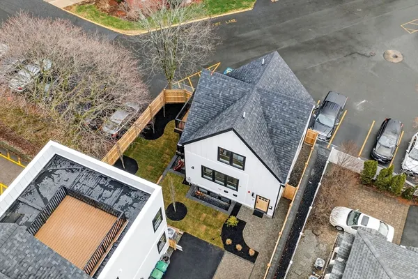 a view of a white house with large windows and a small yard