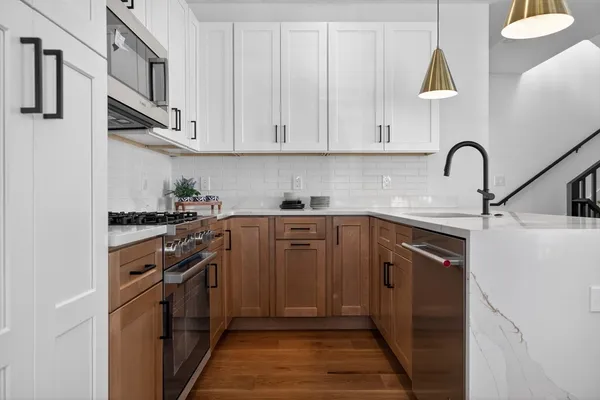 a kitchen with stainless steel appliances granite countertop a stove a sink and a refrigerator