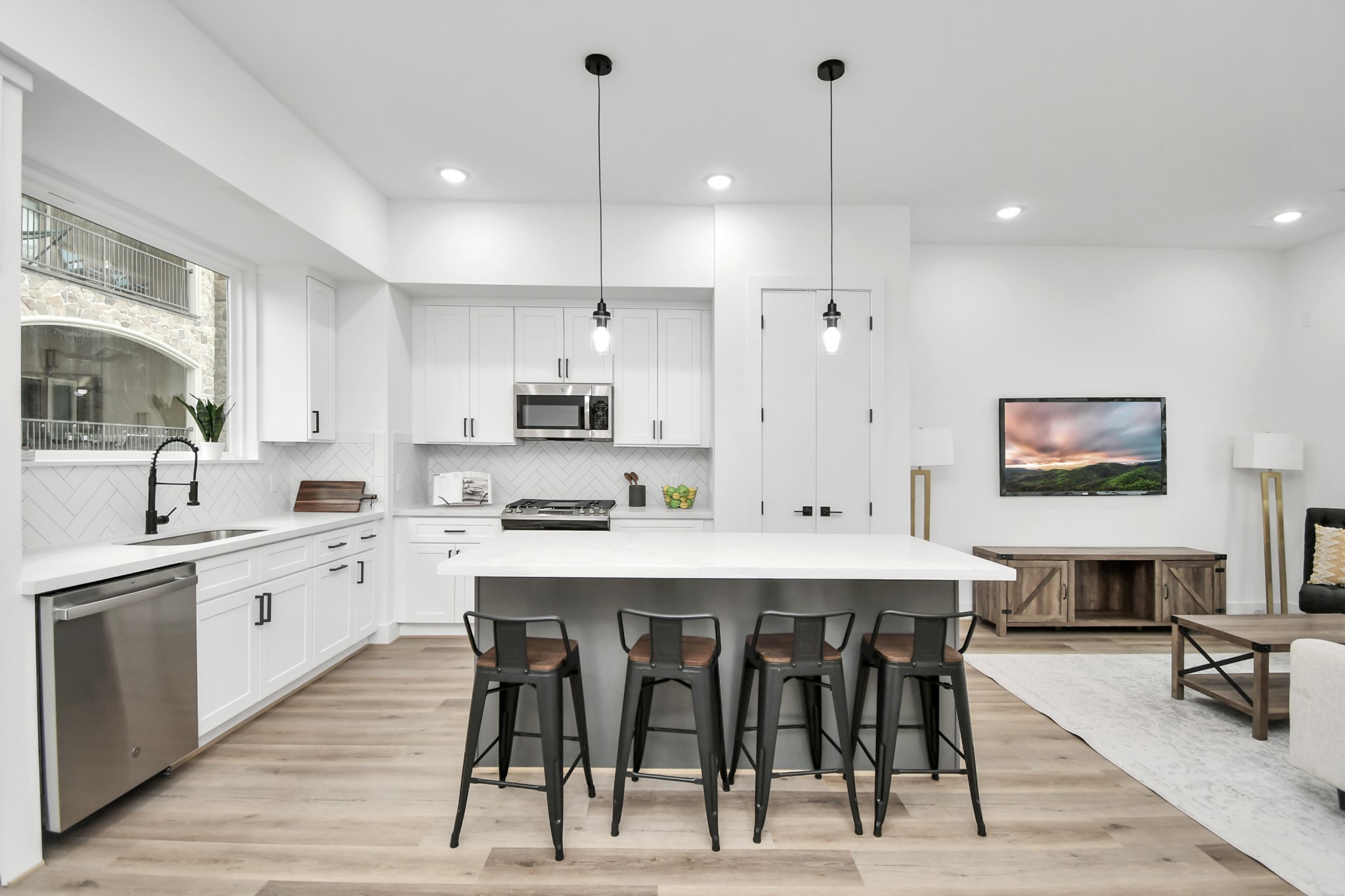 4804 Elysian Street, Unit D Houston, TX 77009 - Photo 13 of 44 a large kitchen with stainless steel appliances kitchen island granite countertop a stove a sink a dining table and chairs with wooden floor