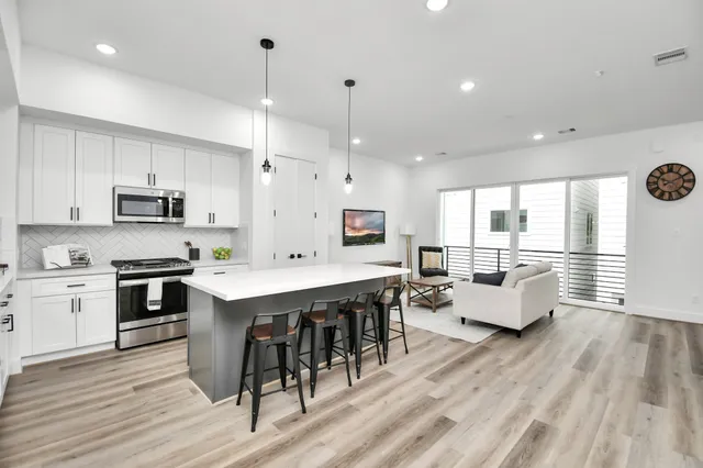 a large kitchen with stainless steel appliances kitchen island granite countertop a large island in the center