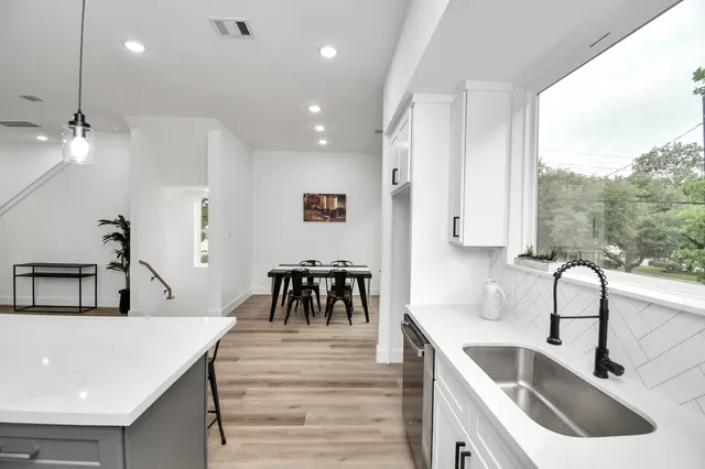 a kitchen with counter top a sink a window and stainless steel appliances