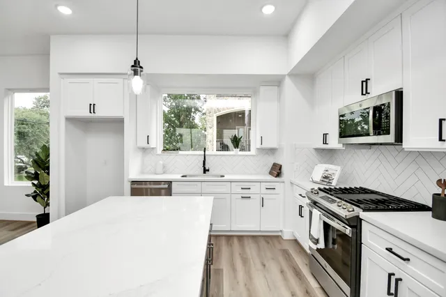 a kitchen with stainless steel appliances a stove sink and cabinets
