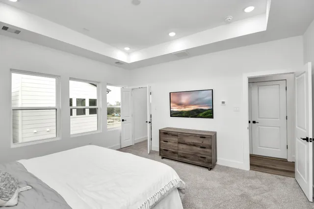 a spacious bedroom with a bed and a flat screen tv