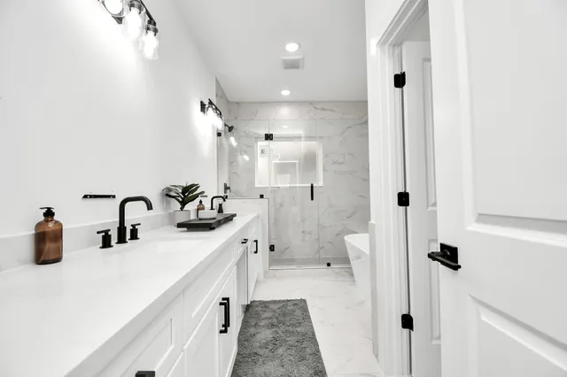 a bathroom with a double vanity sink mirror and shower