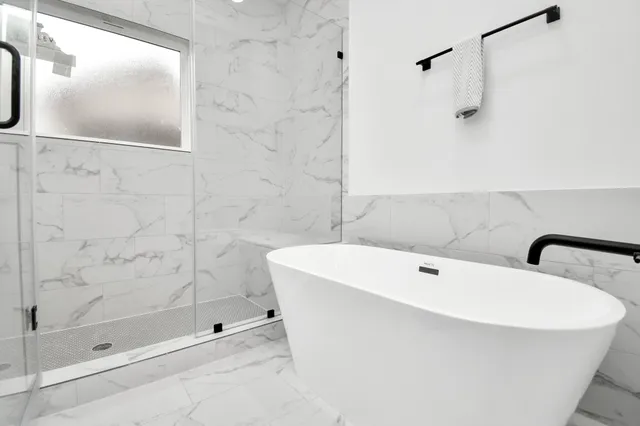 a bathroom with a white bath tub and shower