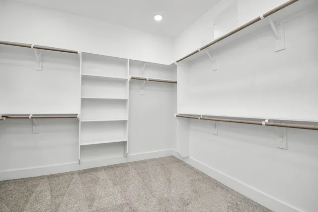 a view of walk in closet with empty racks