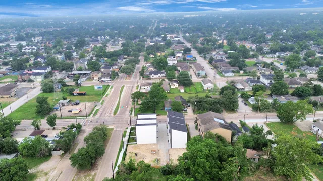 an aerial view of residential houses with outdoor space and trees