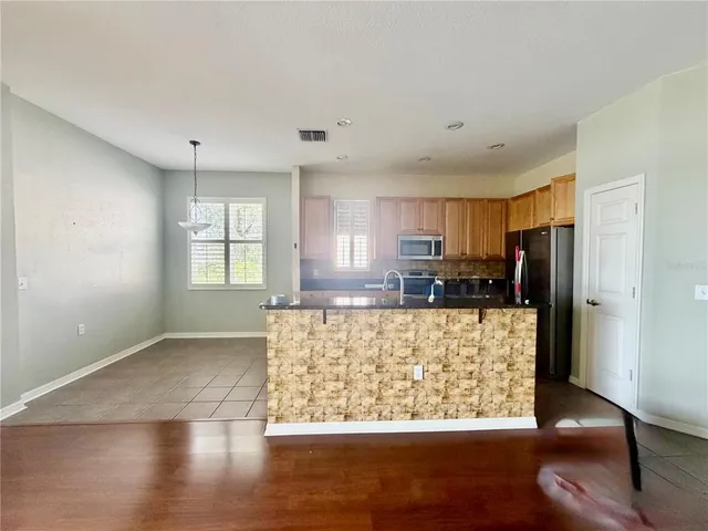 a view of kitchen with refrigerator and window