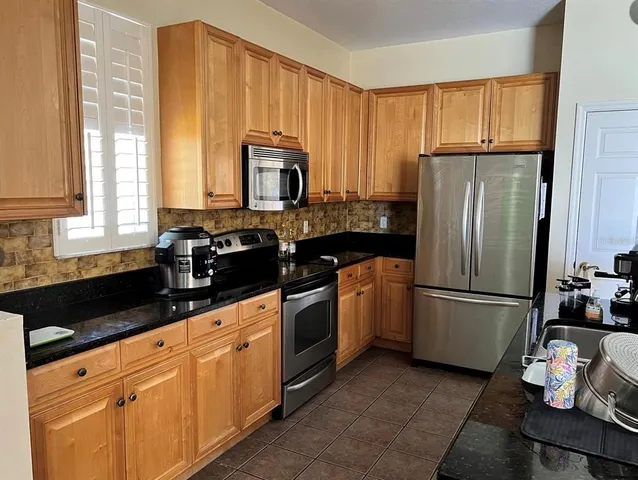 a kitchen with a refrigerator sink and cabinets