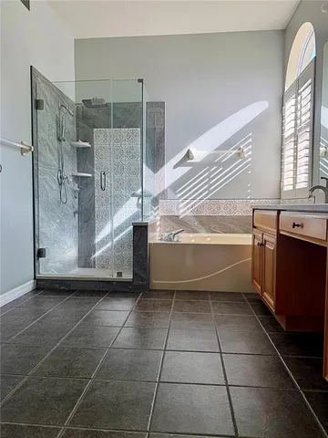 a bathroom with a tub a sink a mirror and a shower
