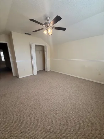a view of an empty room with a chandelier fan