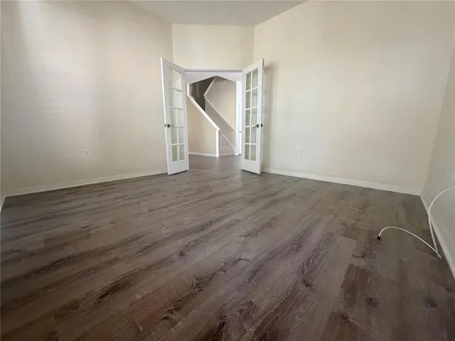 an empty room with wooden floor and entryway