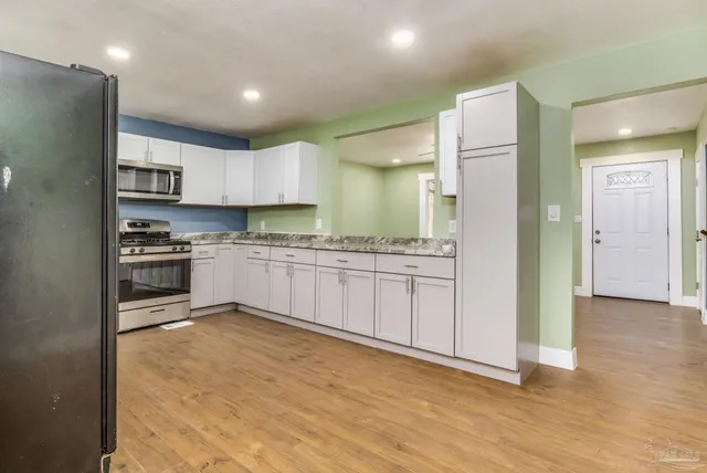a kitchen with stainless steel appliances granite countertop a stove a sink and a refrigerator