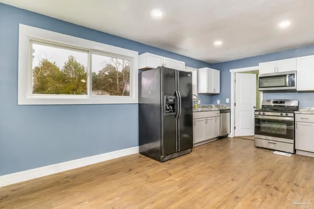a kitchen with stainless steel appliances granite countertop a refrigerator and a stove top oven