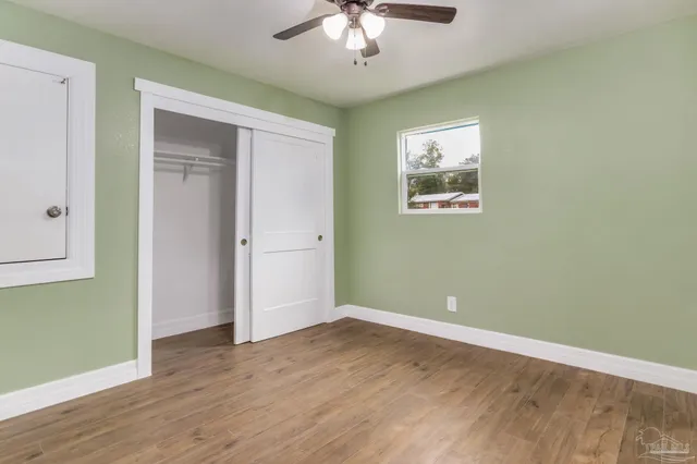 an empty room with wooden floor chandelier and entryway