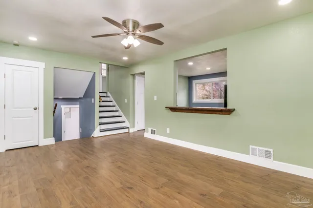 a view of a room with wooden floor and ceiling fan