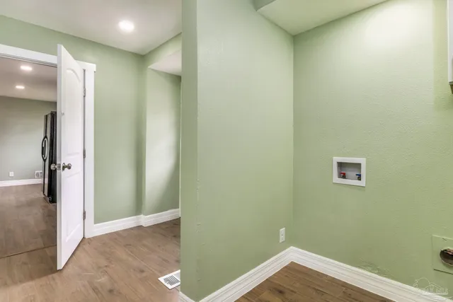 an empty room with wooden floor and entrance
