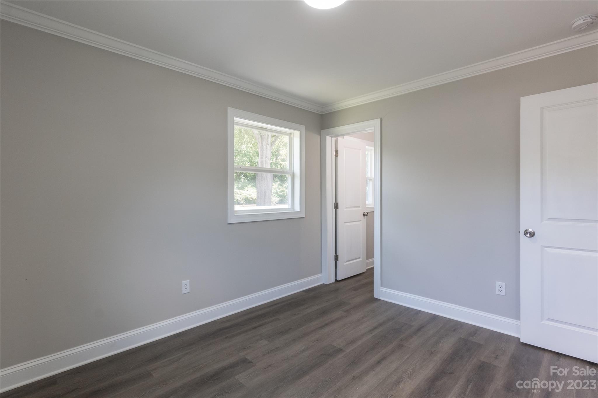 1531 Ruth Street, Unit 2 Lancaster, SC 29720 - Photo 21 of 33 an empty room with wooden floor and windows