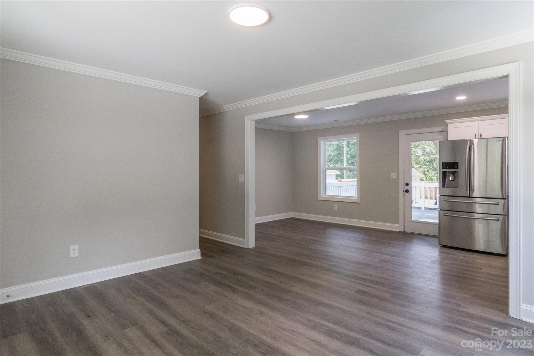 1531 Ruth Street, Unit 2 Lancaster, SC 29720 - Photo 4 of 33 an empty room with wooden floor and kitchen view