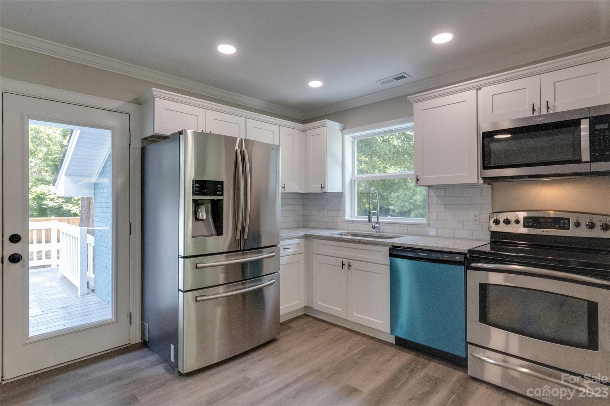 1531 Ruth Street, Unit 2 Lancaster, SC 29720 - Photo 7 of 33 a kitchen with stainless steel appliances granite countertop a stove a refrigerator and a microwave