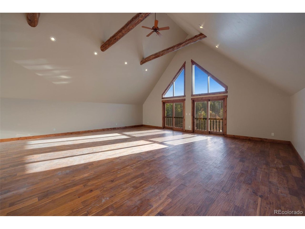 5200 Jackson Road Walden, CO 80480 - Photo 25 of 40 Large greatroom with ceiling fans, sliding glass for natrual air movement and catching the sounds of the outdoors that echo through the large vaulted ceilings, additional wet bar and refrigerator out of view but positioned on the left side of the room