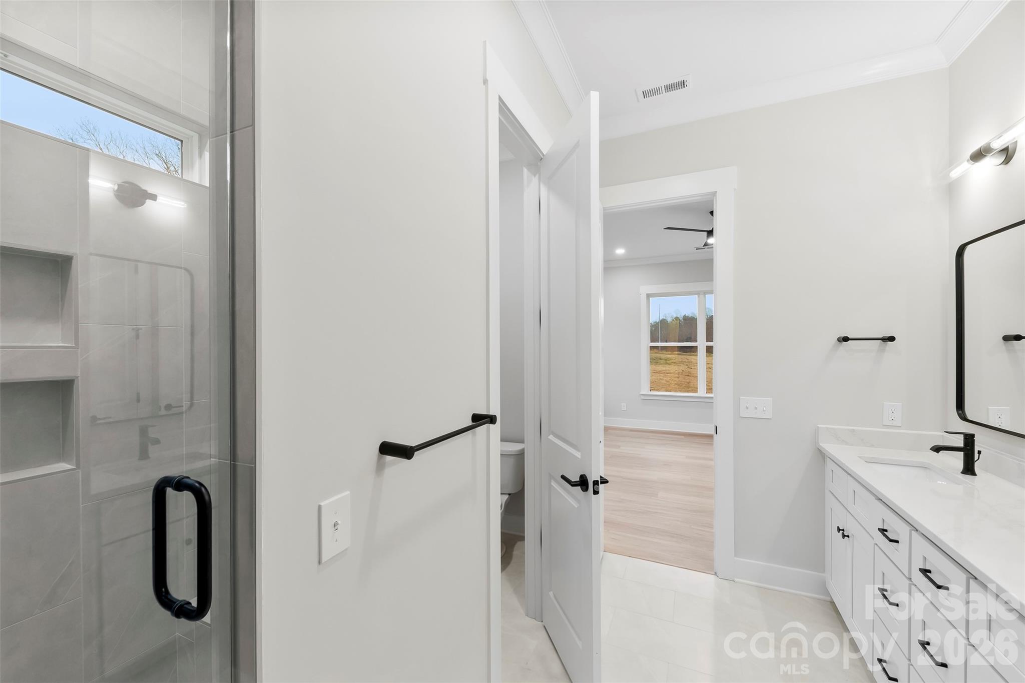 551 Perry Road Troutman, NC 28166 - Photo 21 of 47 a bathroom with a double vanity sink a mirror a bathtub and shower