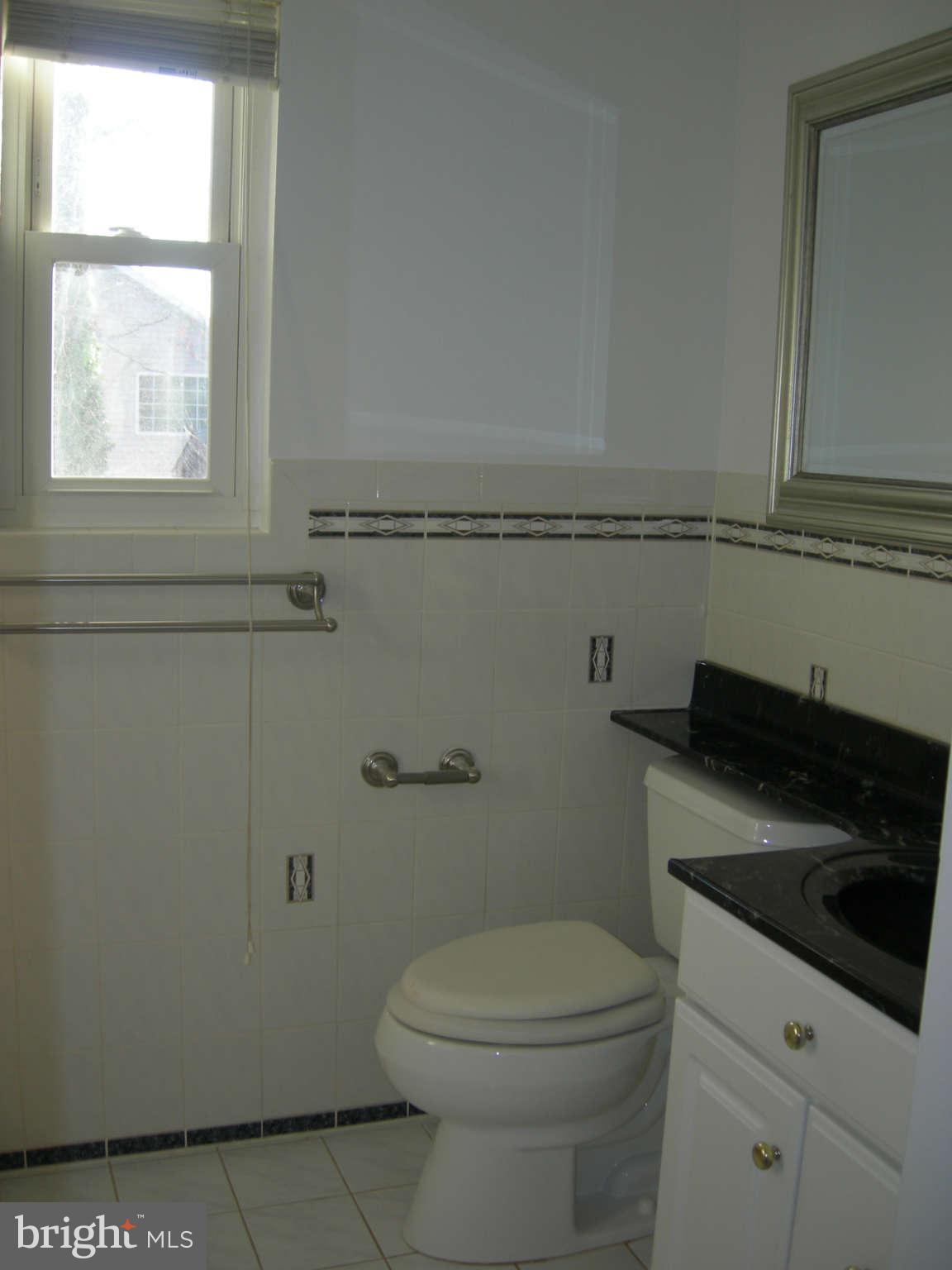 5218 Montgomery Street Springfield, VA 22151 - Photo 4 of 8 a bathroom with a toilet a sink a vanity and window