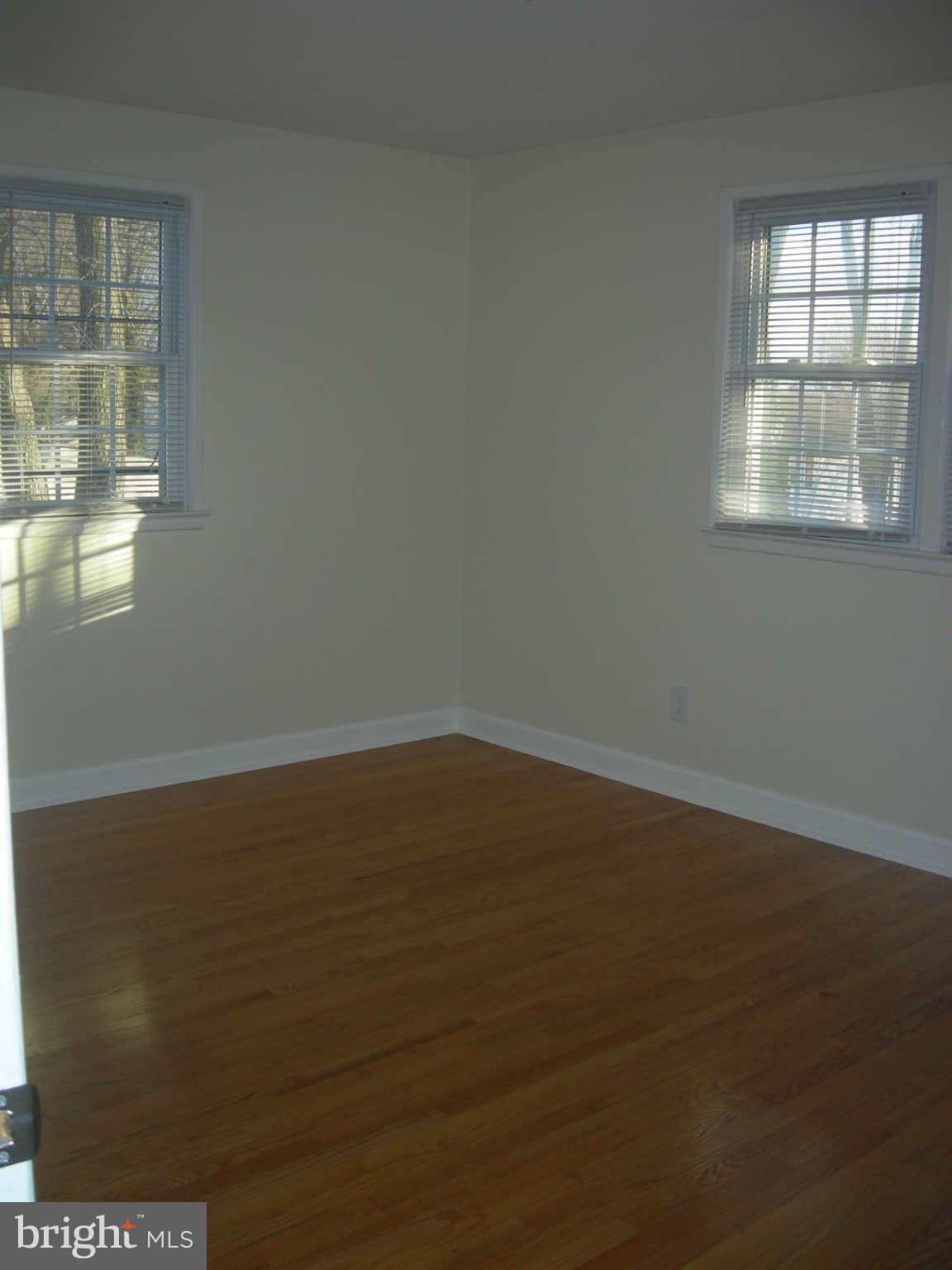5218 Montgomery Street Springfield, VA 22151 - Photo 5 of 8 an empty room with wooden floor and windows