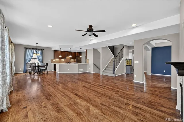 a view of an empty room with wooden floor fireplace and a window