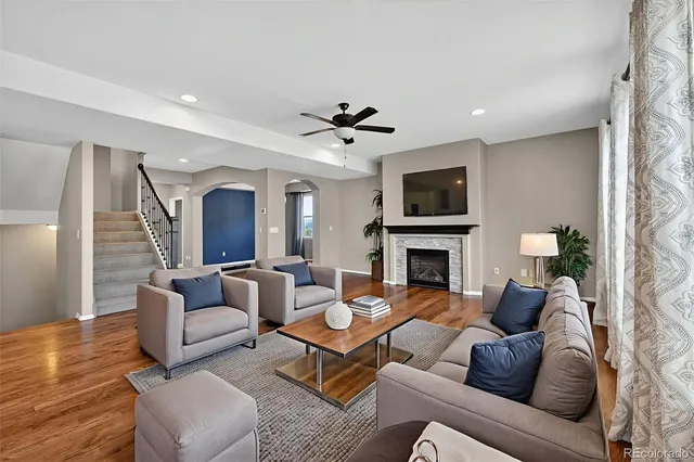 a view of an empty room with wooden floor and a fireplace