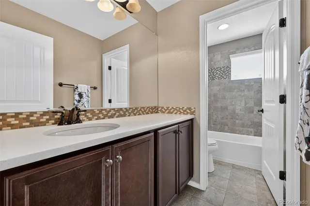 a view of a livingroom with a ceiling fan & entryway