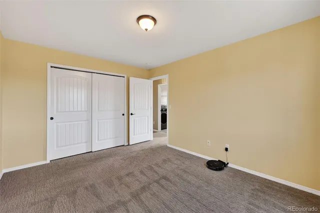 an empty room with a window and ceiling fan