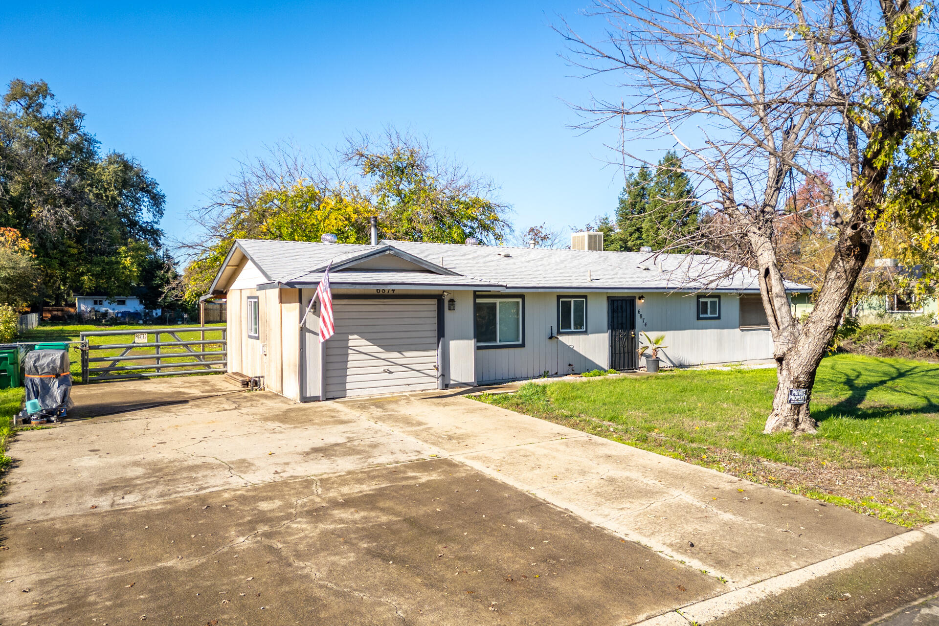 6874 Weeks Road Redding, CA 96002 - Photo 3 of 26 a front view of a house with a garden and trees