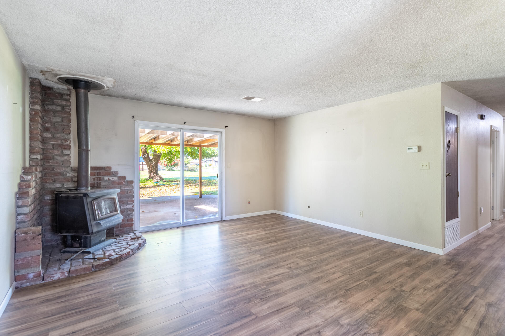6874 Weeks Road Redding, CA 96002 - Photo 5 of 26 a view of empty room with fireplace and wooden floor