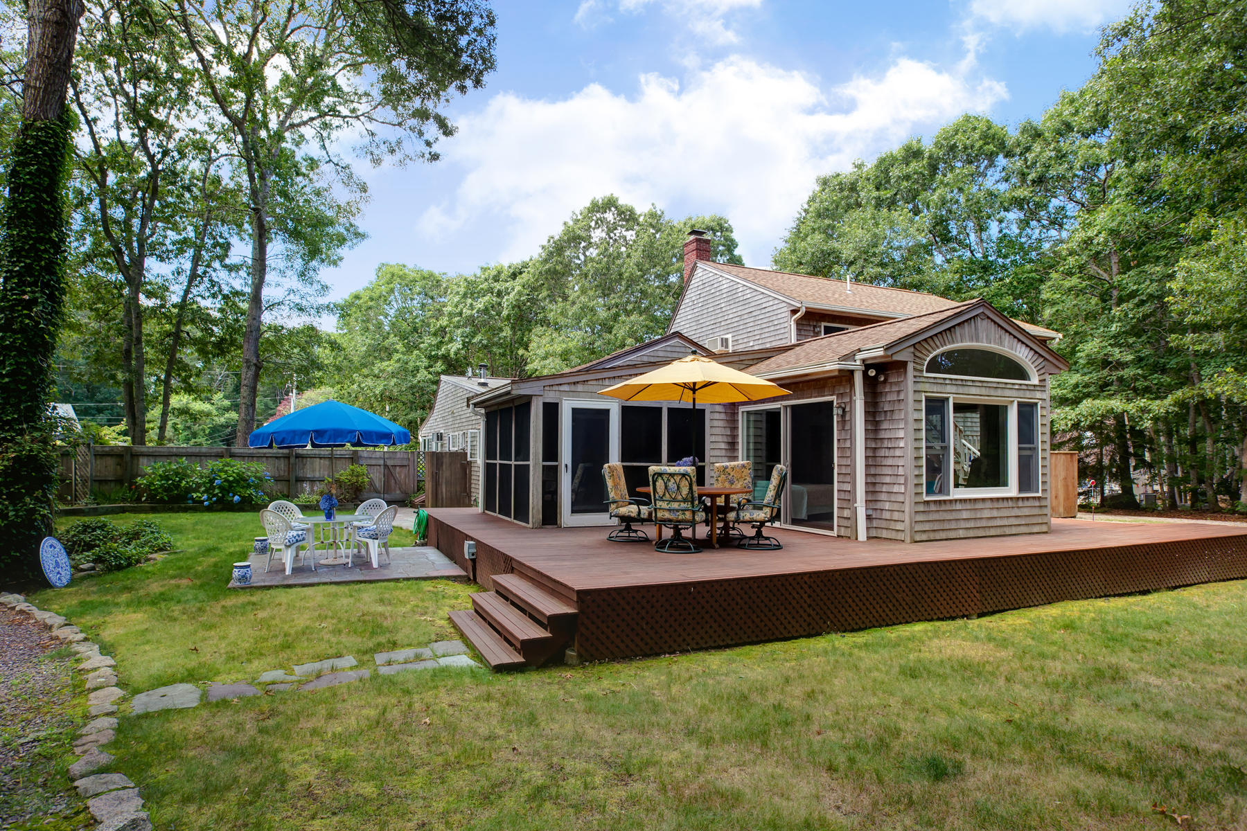 18 Frederick Road Falmouth, MA 02540 - Photo 23 of 62 a patio area with table and chairs under an umbrella