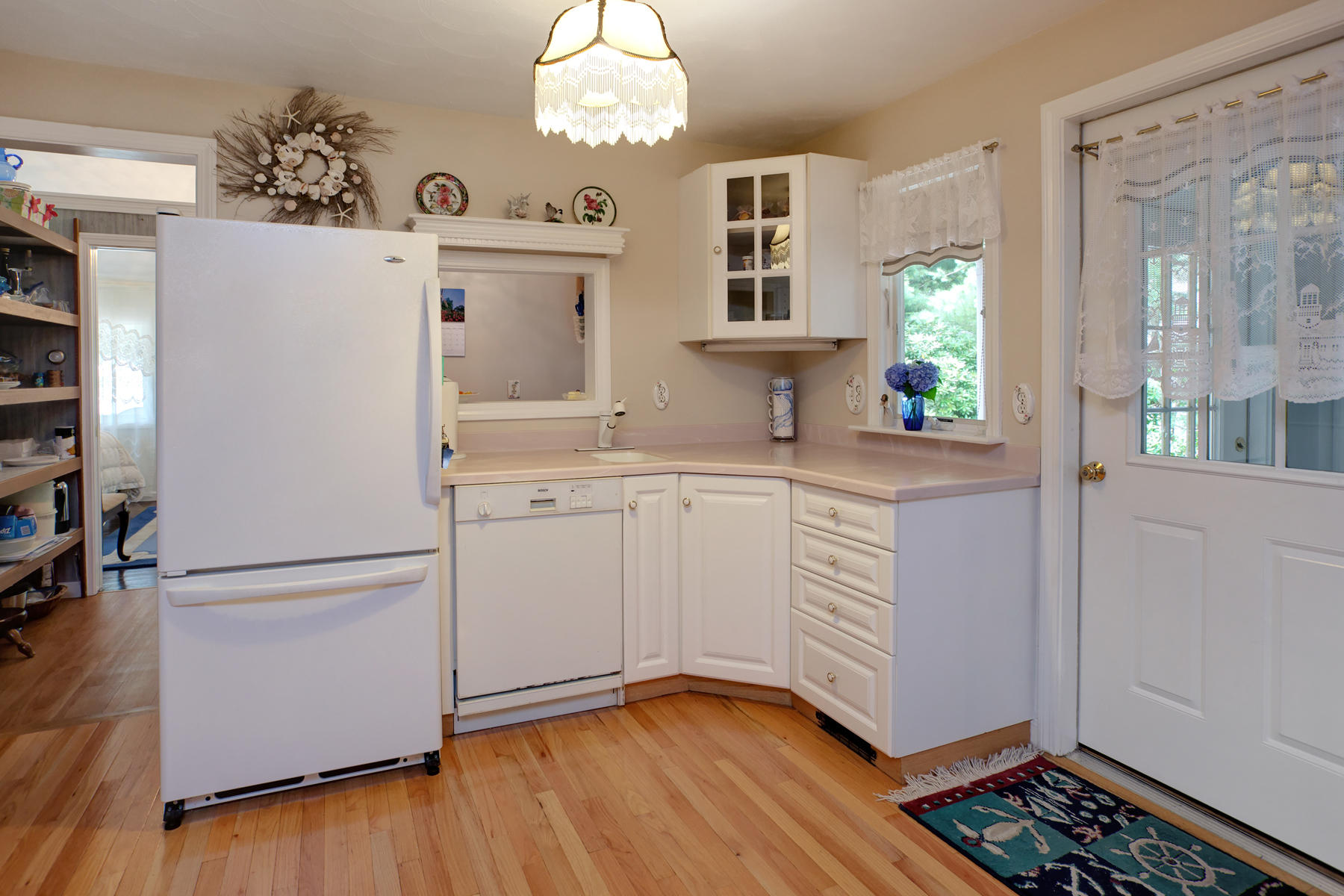 18 Frederick Road Falmouth, MA 02540 - Photo 40 of 62 a kitchen with white cabinets and wooden floor