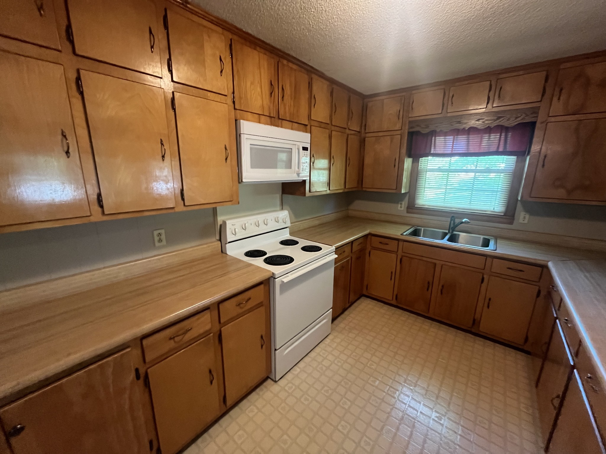 1619 Railroad Bed Road Collinwood, TN 38450 - Photo 12 of 54 a kitchen with stainless steel appliances granite countertop a sink stove and refrigerator