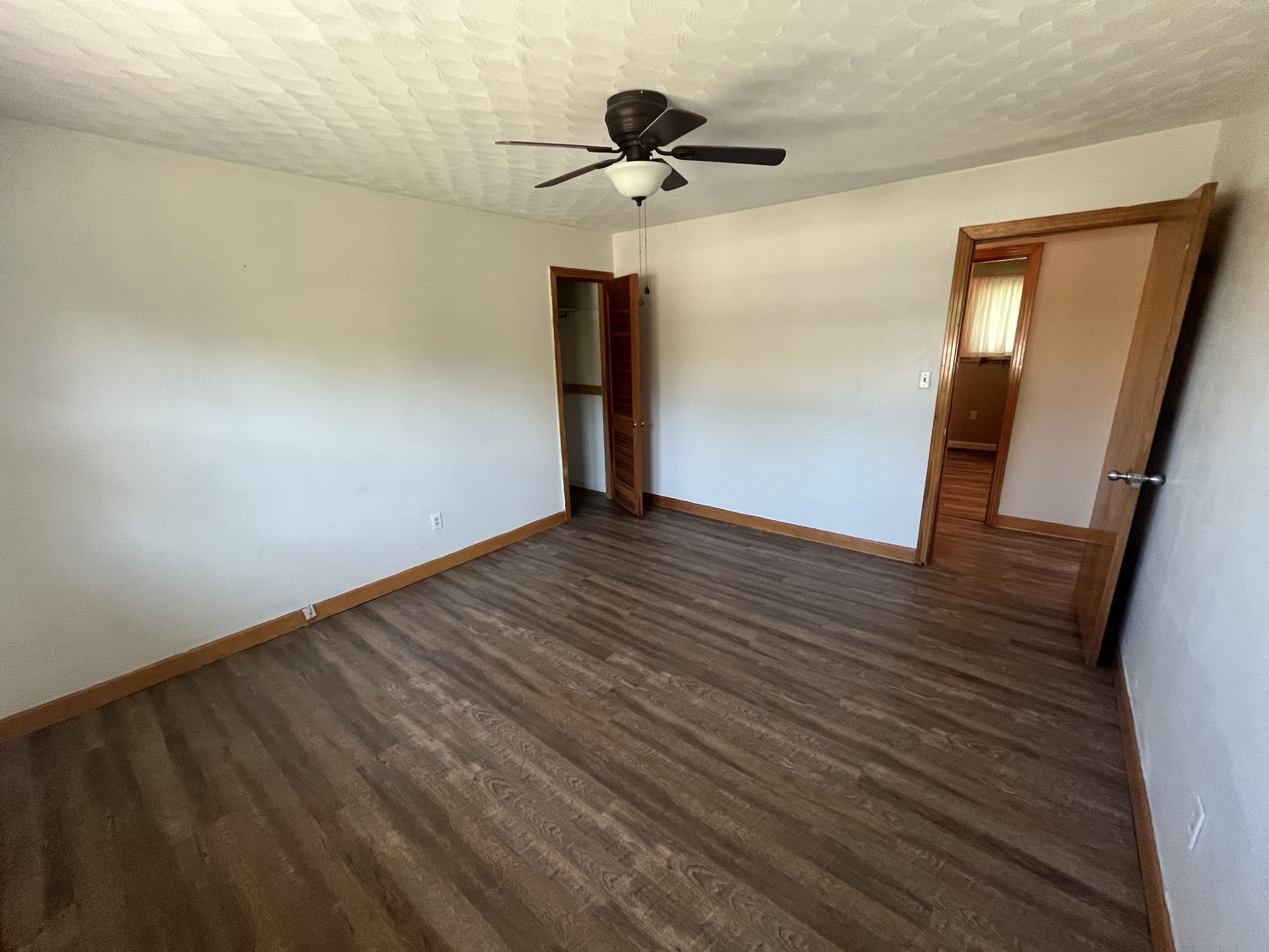 1619 Railroad Bed Road Collinwood, TN 38450 - Photo 19 of 54 a view of an empty room with wooden floor and a ceiling fan