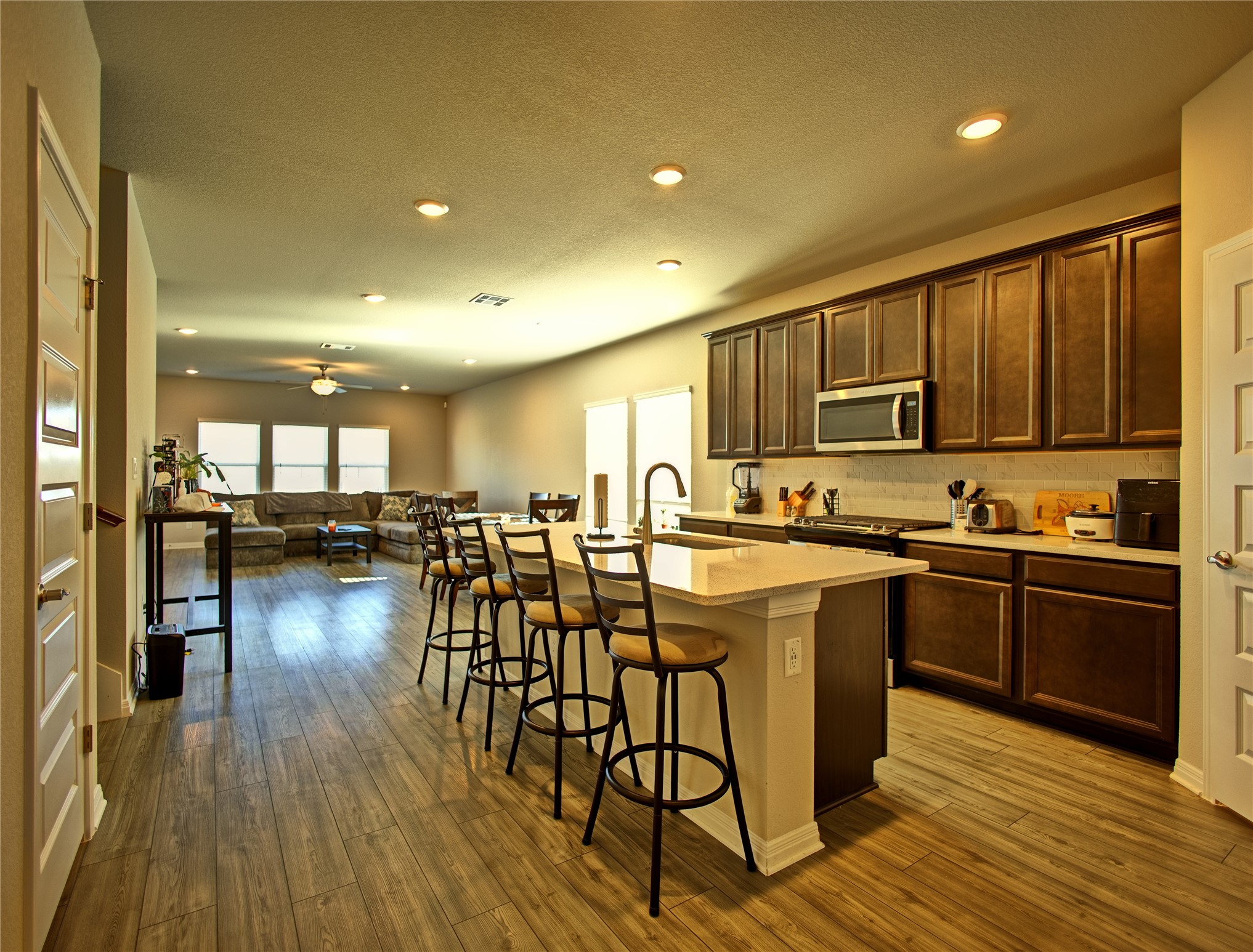 2809 Moyer Lane Round Rock, TX 78665 - Photo 22 of 22 Kitchen with a center island with sink, a kitchen breakfast bar, stainless steel appliances, open floor plan, and dark wood finished floors