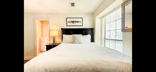 a large bedroom with a bed and a large window
