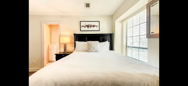 a large bedroom with a bed and a large window