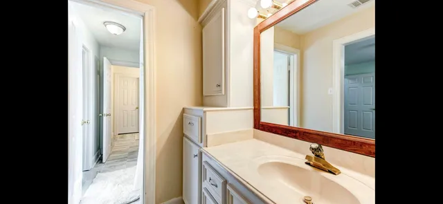 a bathroom with a granite countertop sink and a mirror
