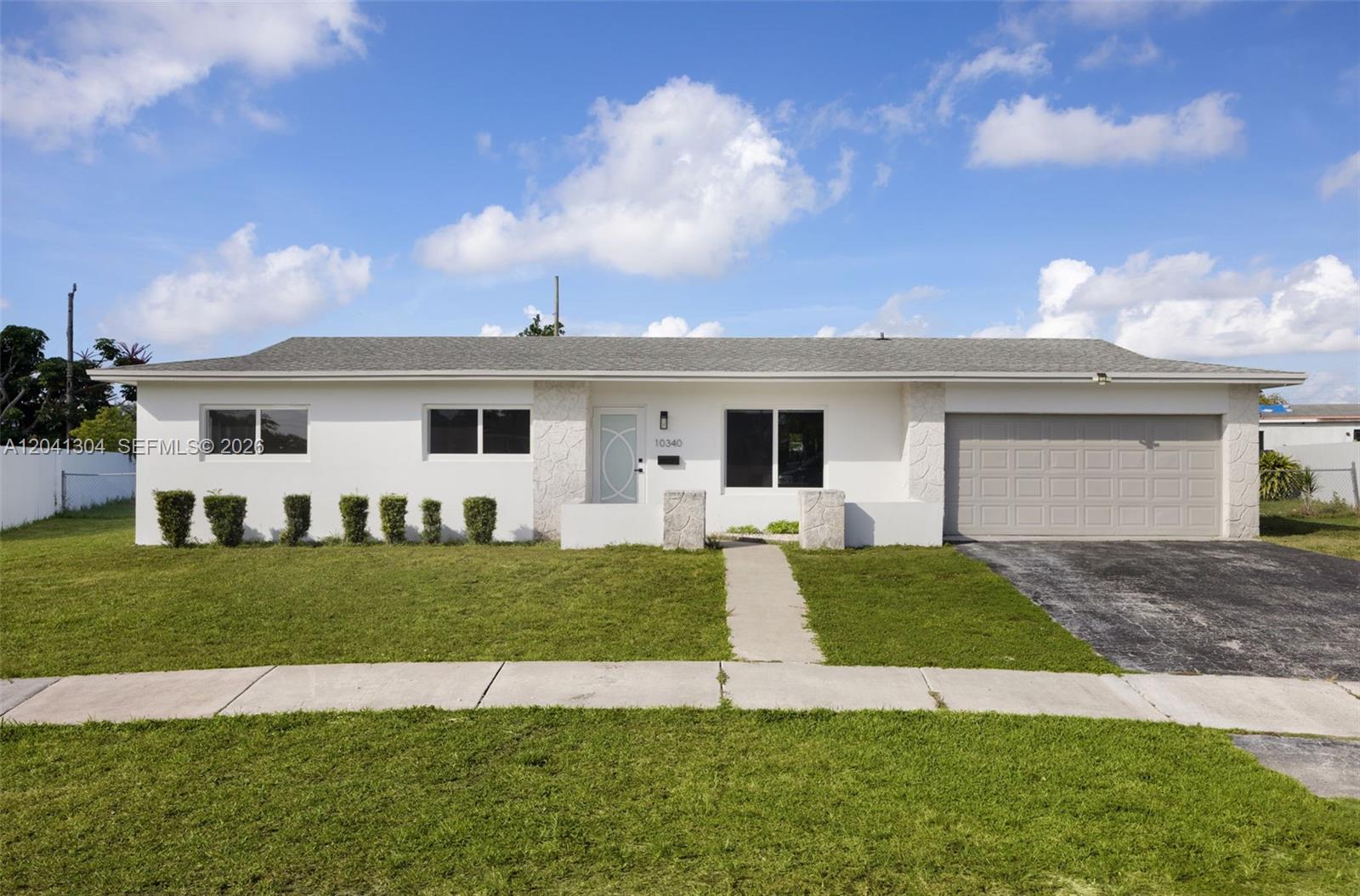 Front Elevation – Contemporary curb appeal highlighted by a crisp neutral color palette, manicured landscaping, and a covered entryway. The wide frontage enhances the home's attractive street presence.