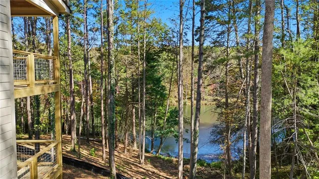 an aerial view of residential house with outdoor space and trees all around