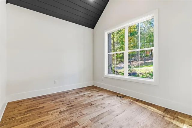a view of empty room with wooden floor